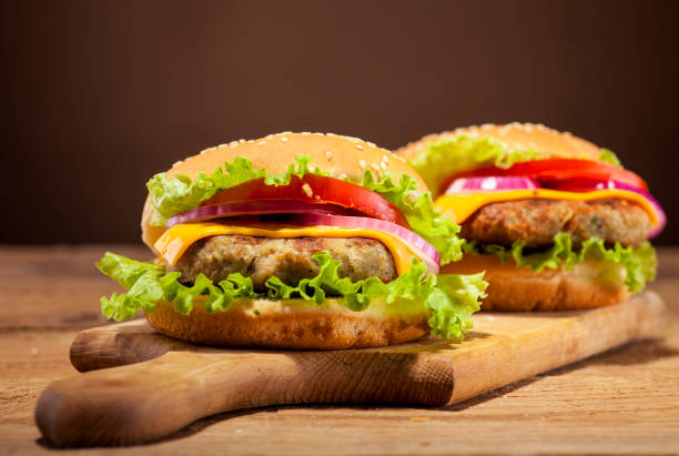 istock Fresh burgers on wooden background 664048132