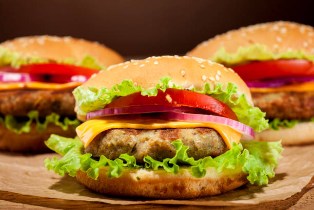 istock Fresh burgers on wooden background 664048150