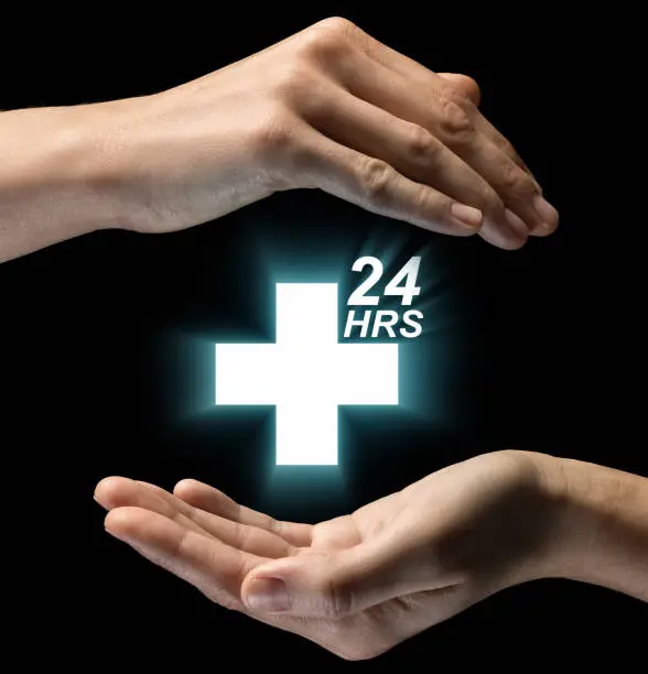 Isolated image of two hands on black background. Round-the-clock medical care icon in the center. Concept of Round-the-clock medical care.