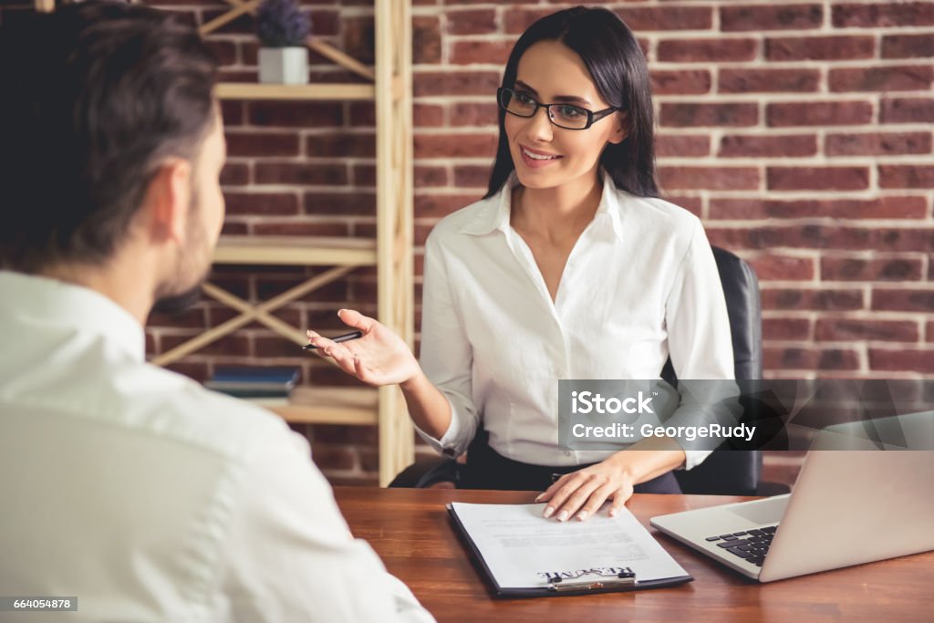 At the job interview Beautiful female employer in suit is conducting a job interview while sitting in her office Asking Stock Photo