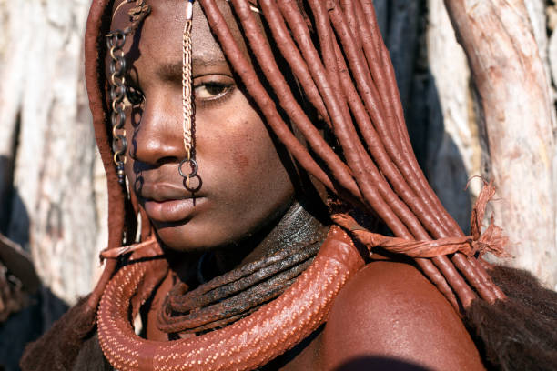 Himba woman portrait. EPUPA, NAMIBIA - 12TH MAY 2016 - A Himba woman poses for a photo during a village visit. The Himba villages around Epupa welcome visitors in exchange for food and the chance to sell their crafts. kaokoveld stock pictures, royalty-free photos & images