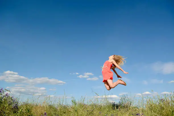 Frau macht Freudensprungjoyful young blond woman leaping