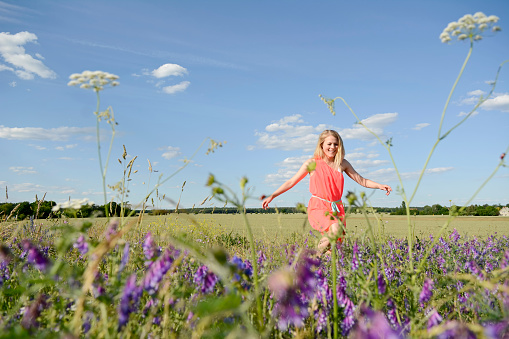 young woman on flower meadow happy young woman walking on flower meadow