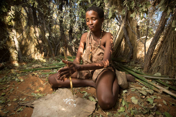 GRASHOEK, NAMIBIA - 22ND MAY 2016 -  A Ju Hoansi villager makes beads as part of a cultural demonstration. The San display their culture to visitors in order to preserve ancient traditions and stories