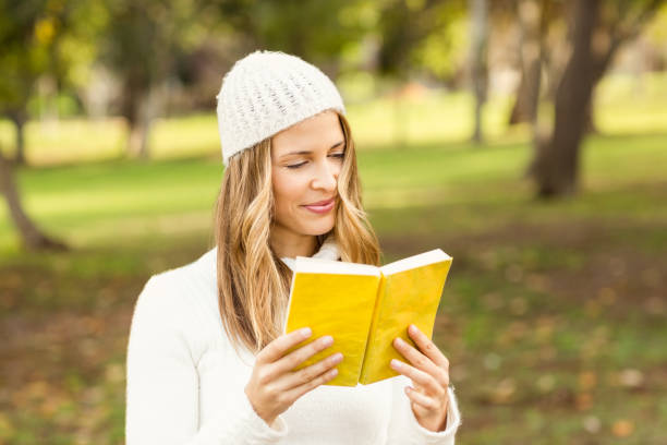 istock Smiling pretty woman reading a book 664071792