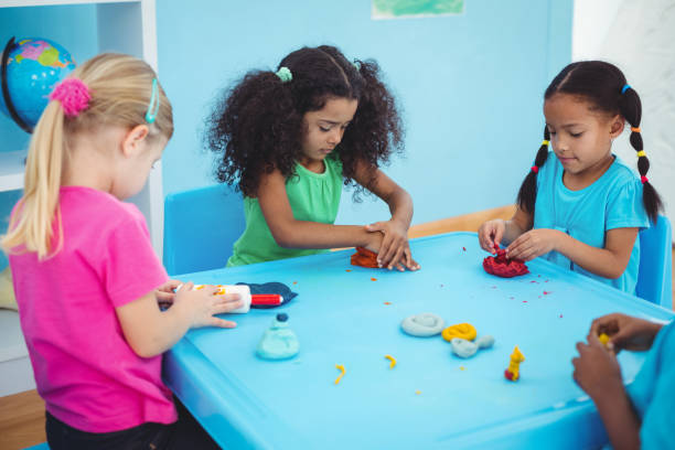 istock Smiling girls playing with modelling clay 664072268