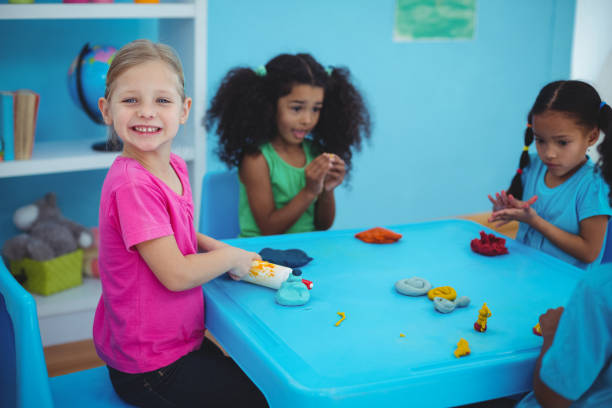 istock Smiling girls playing with modelling clay 664072398