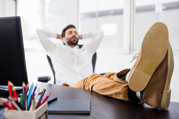 istock Relaxing man with his leg crossed on the desk 664074782