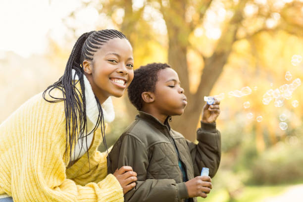 istock Little boy doing some bubbles with his mother 664077494