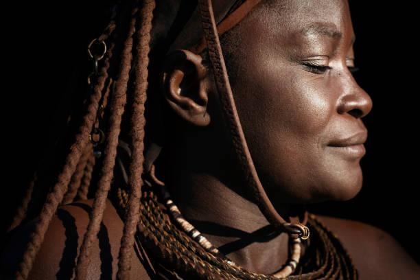 Himba woman portrait. EPUPA, NAMIBIA - 12TH MAY 2016 - A Himba woman poses for a photo during a village visit. The Himba villages around Epupa welcome visitors in exchange for food and the chance to sell their crafts. kaokoveld stock pictures, royalty-free photos & images