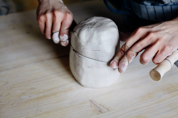 istock Woman hands close-up, forming crude clay in a potter's workshop studio. Craft-work 664077776