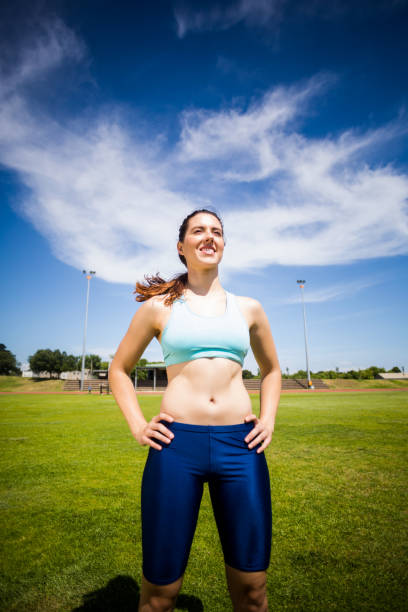 Confident female athlete standing with hand on hip