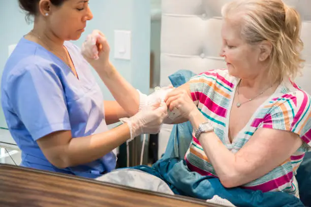 Photo of Home healthcare nurse tending to picc line of recovering patient