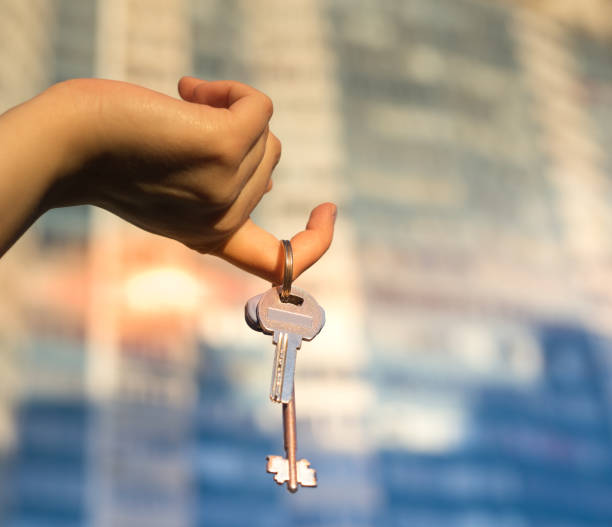 istock Hand holding key with modern building on background. 664103718