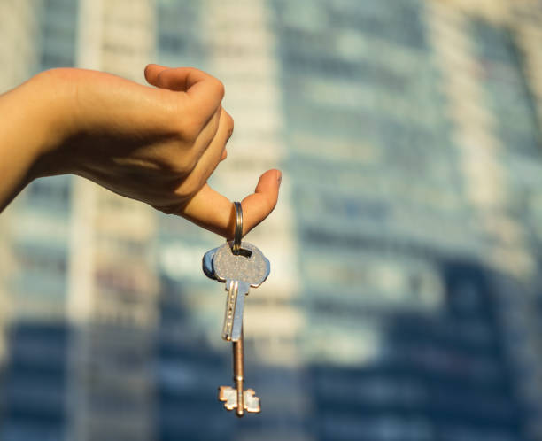 istock Hand holding key with modern building on background. 664103862