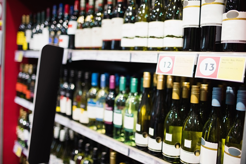Focus on wine bottle shelf in supermarket