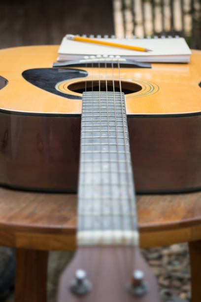 istock Yellow Acoustic Guitar On Wooden Table 664106664