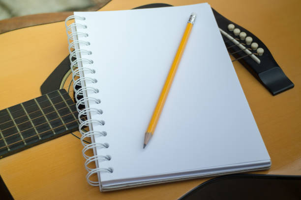 istock Yellow Acoustic Guitar On Wooden Table 664106666
