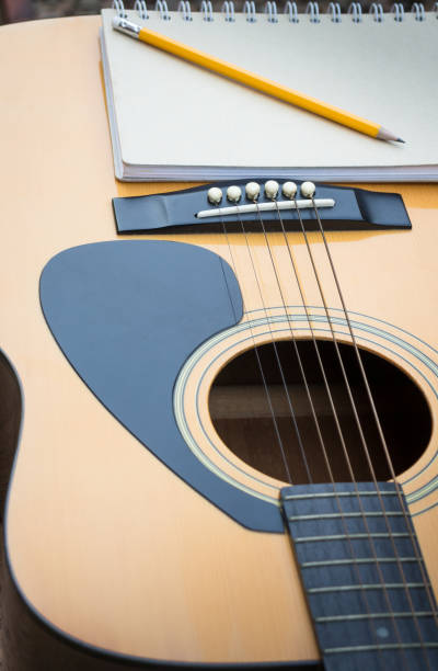 istock Yellow Acoustic Guitar On Wooden Table 664106682