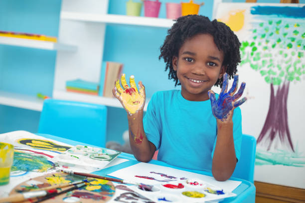 istock Happy kid enjoying painting with his hands 664113128