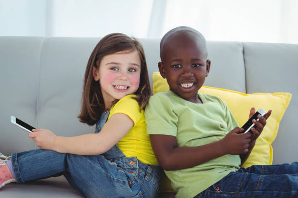 istock Smiling girl and boy using mobile phones 664118638