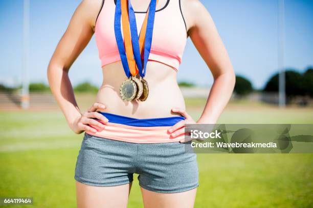 Mid Section Of Female Athlete With Gold Medals Around Her Neck Stock Photo - Download Image Now