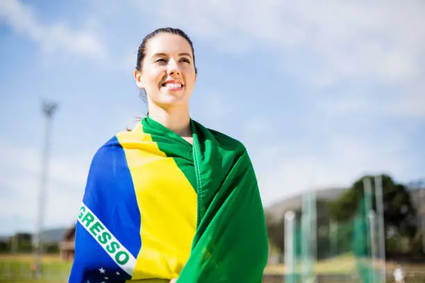 Happy female athlete wrapped in Brazilian flag
