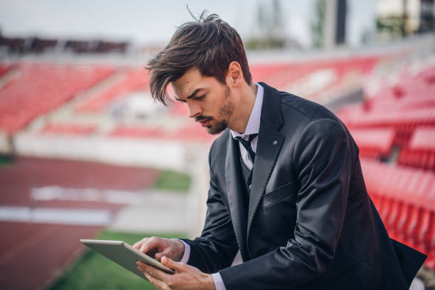 istock Man in suit on bleachers 664122198