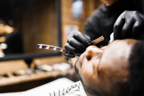 Shave with razor blade Barber shaving face of his client glove box stock pictures, royalty-free photos & images