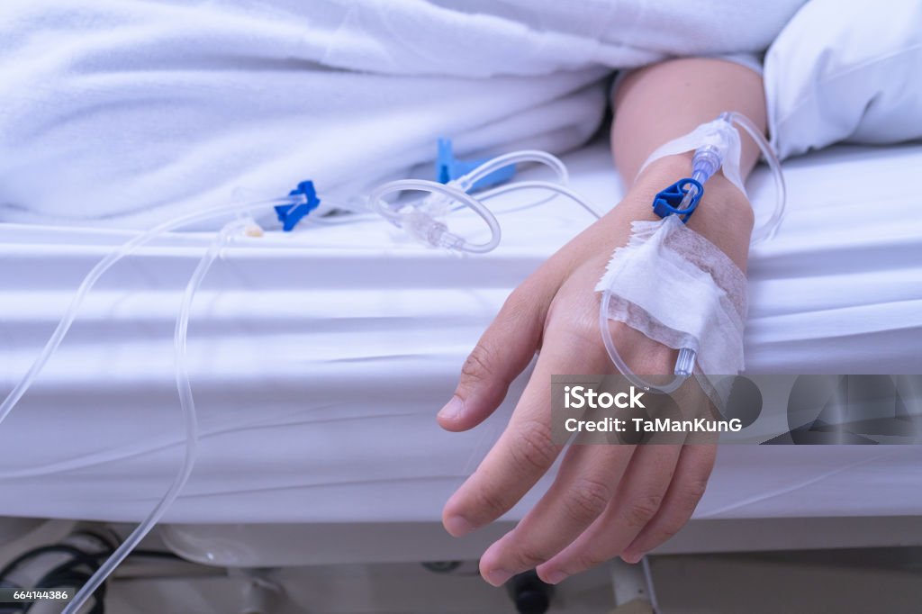 Asian Lady Hand received a Saline Solution injection Hospital Stock Photo