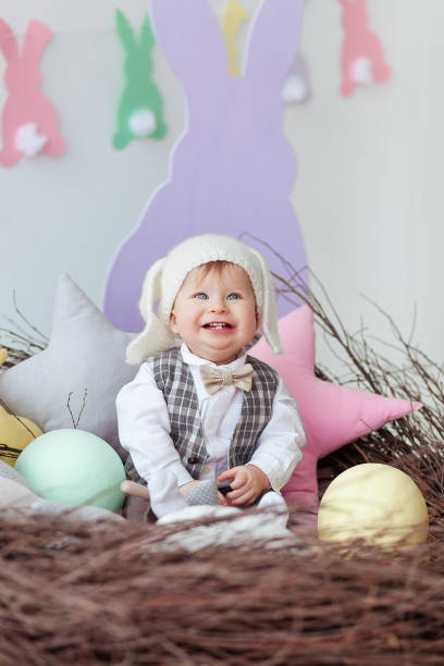 divertido bebé niño vestido con traje de conejito de pascua en un nido - baby animal nest newborn lying down fotografías e imágenes de stock