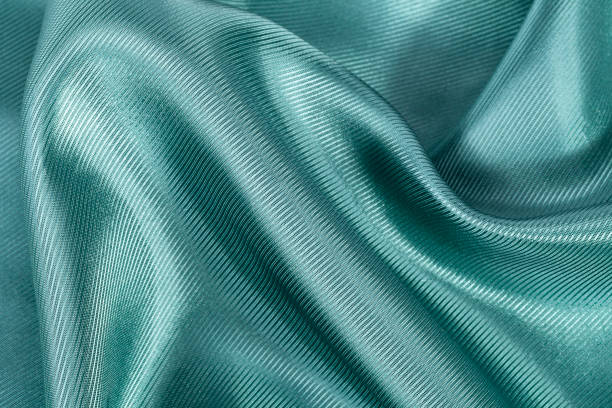 istock Silk background, texture of green  shiny ribbed fabric, close up 664149264