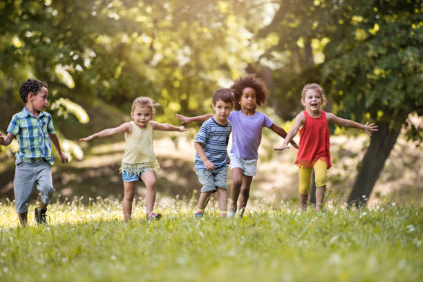 istock Group of happy children having fun while running in nature. 664149588