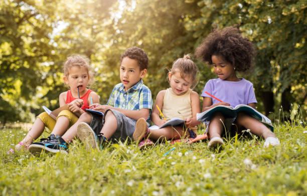 istock Four small friends relaxing in nature and drawing in notebooks. 664149718
