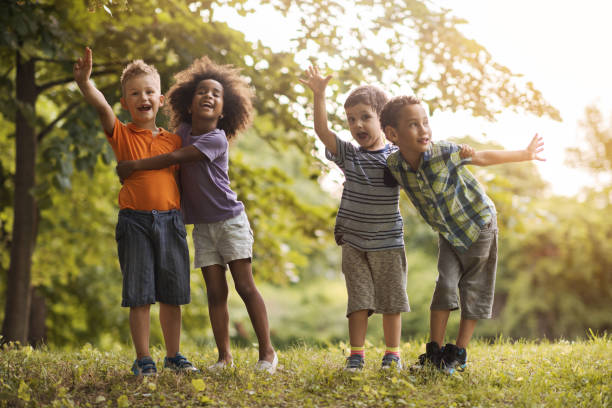 istock Four embraced kids having fun during spring day in nature. 664152394