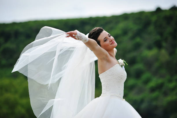 istock beautiful brunette bride play with veil on the wind 664155984