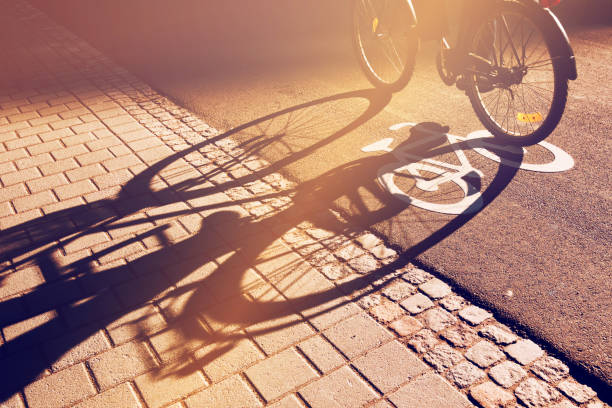 istock Shadow of unrecognizable cyclist riding a bike on bicycle lane 664156876