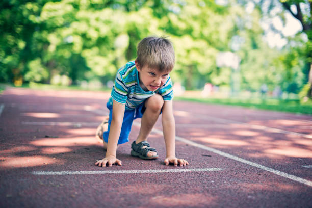 istock Little boy preparing for run on the running track 664157298