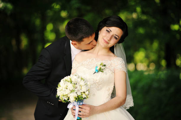 istock groom kisses on the neck bride 664160204