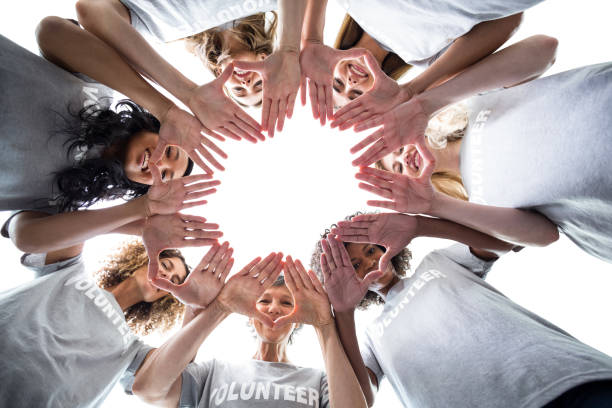 istock Happy volunteers standing in a circle with their hands together 664163454