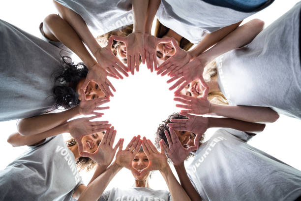 istock Happy volunteers standing in a circle with their hands together 664163544