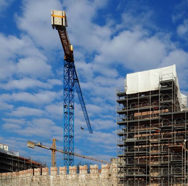 istock Crane in a industrial site with smoke stacks 664170454
