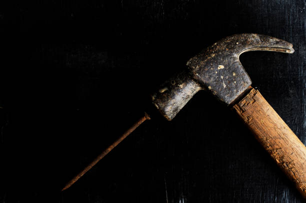 istock Hammer and nail on grunge wood backgrounds 664170860