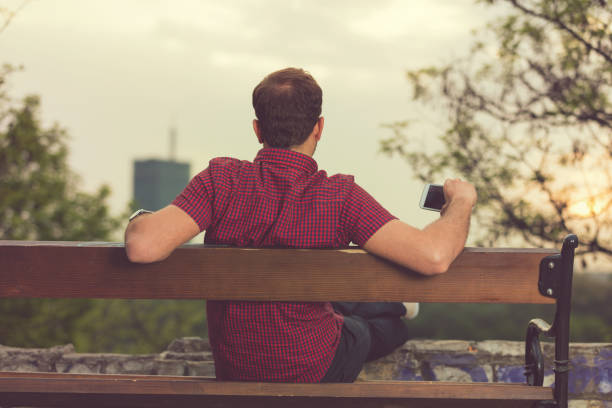 Modern guy holding cellphone and enjoying the view.