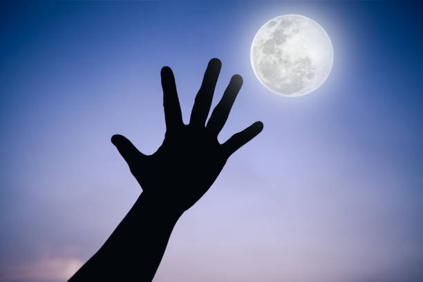 istock Silhouette of a hand with super moon on sky background. 664183416