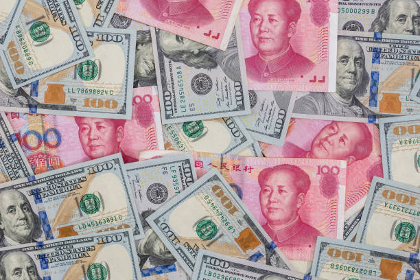 chinese yuan bills  vs  u.s. dollar as background . - investment rmb savings china imagens e fotografias de stock