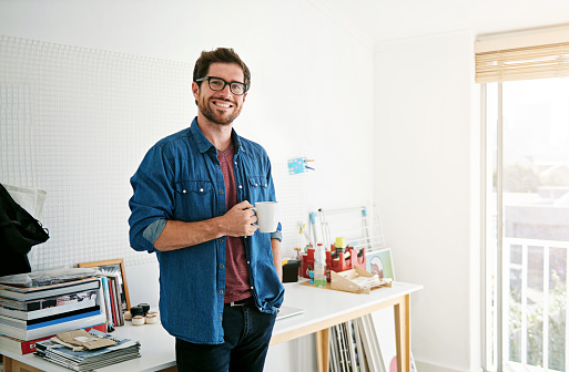 Portrait of a man at home holding a cup of coffee