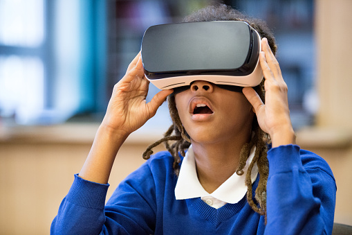 Afro american wearing school uniform using virtual reality goggle.