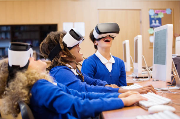 Mixed race group of students using virtual reality goggles Mixed race group of excited students sitting in a computer lab at school and using virtual reality goggles. virtual reality simulator photos stock pictures, royalty-free photos & images