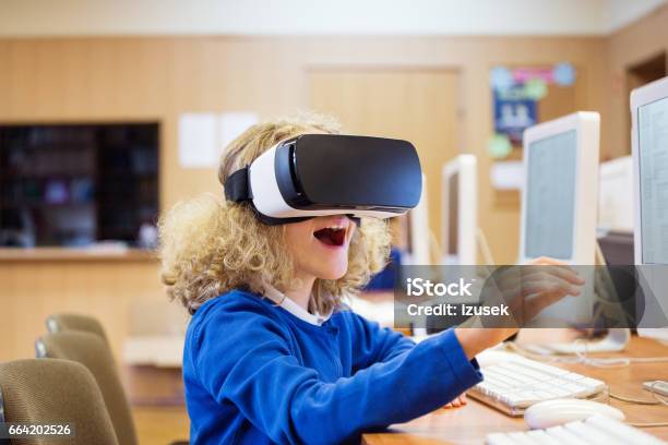 Cute Girl Using Virtual Reality Goggle At School Stock Photo - Download Image Now - Education, Virtual Reality Simulator, Virtual Reality